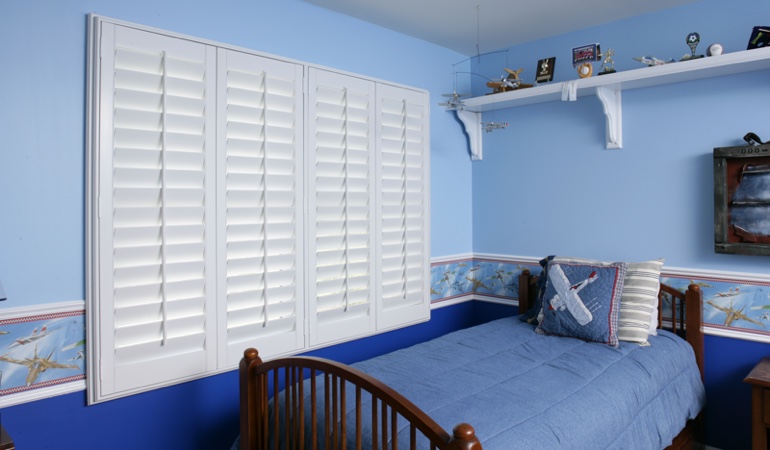 Blue kids bedroom with white plantation shutters in Raleigh 